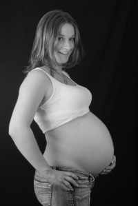 happy healthy pregnant woman on black background